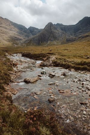 Picturesque view of stream by high mountains