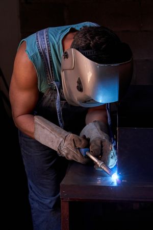 Anonymous man welding metal detail