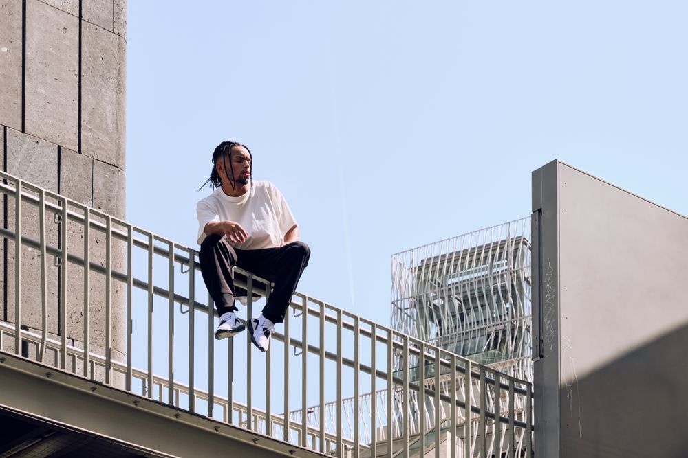 Black male sitting on bridge