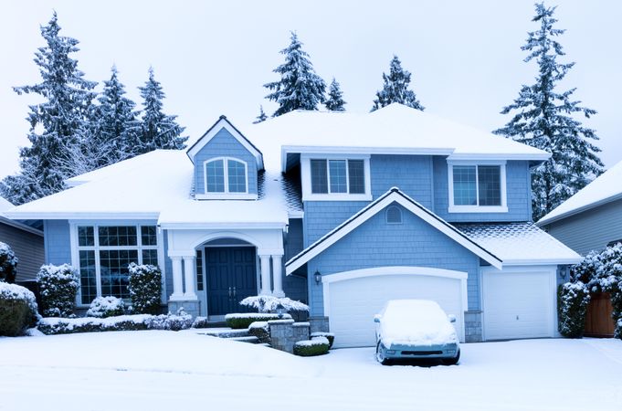 Front view of family home during winter snowfall