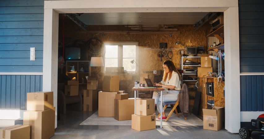 Hispanic Businesswoman Using Laptop Computer In Garage.