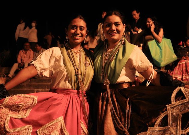 Two women in traditional Mexican dresses at street party