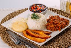Homemade Venezuelan food. Traditional Venezuelan dish. Pabellon Criollo. White Rice, beans, Fried plantains, and Shredded beef