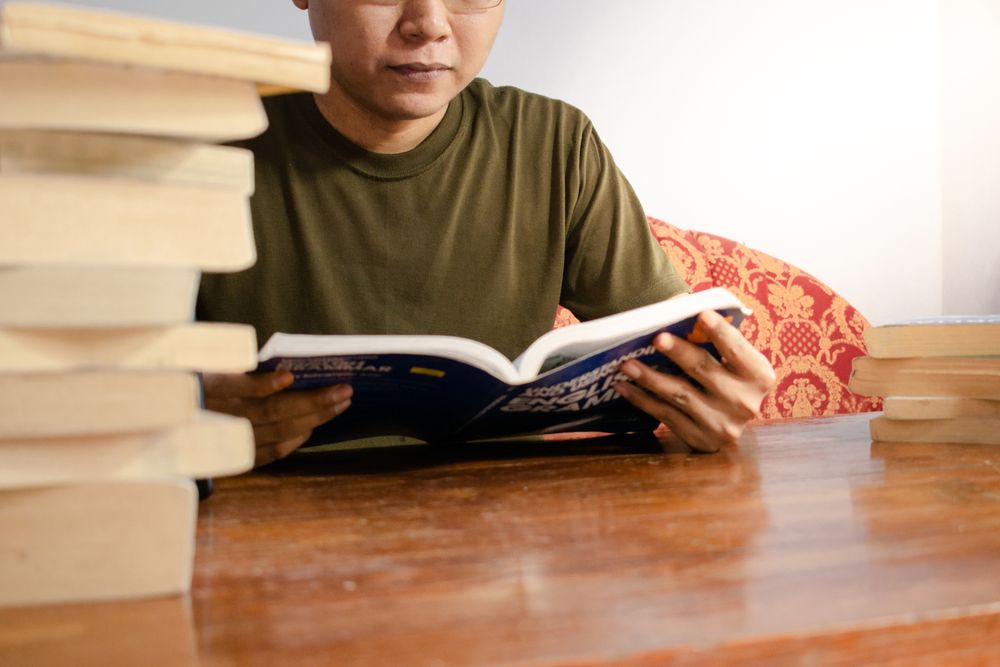 Asian young student study, reading and writing sit on sofa at living room