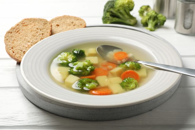 Vegetable soup on wooden table with break