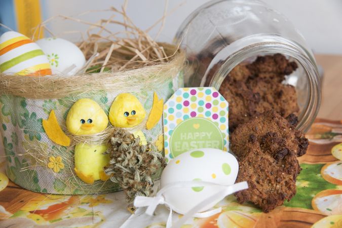 Easter scene of a jar of cookies, marijuana, chicks and decorated eggs