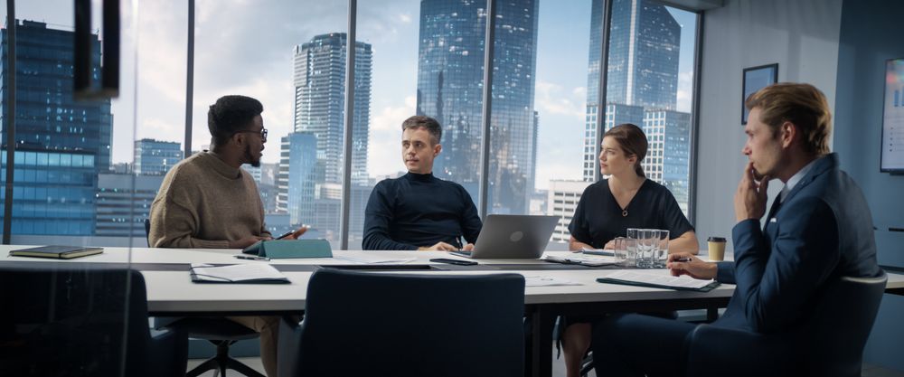 Multiethnic Diverse Office Conference Room Meeting: Team of Three Creative Entrepreneurs Talk, Discuss Growth Strategy.