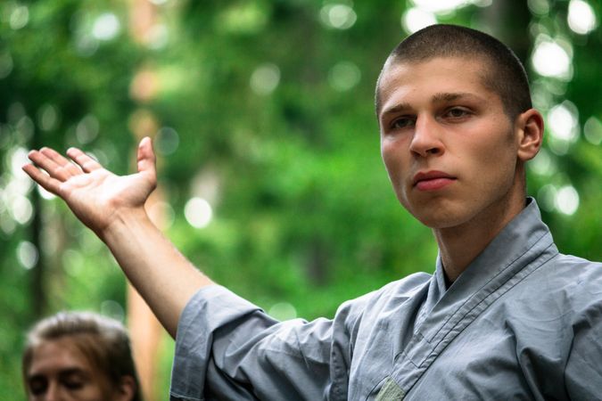 Bald woman practicing martial arts in garden