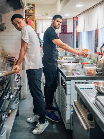 Multiethnic cooks working in kitchen of cafe