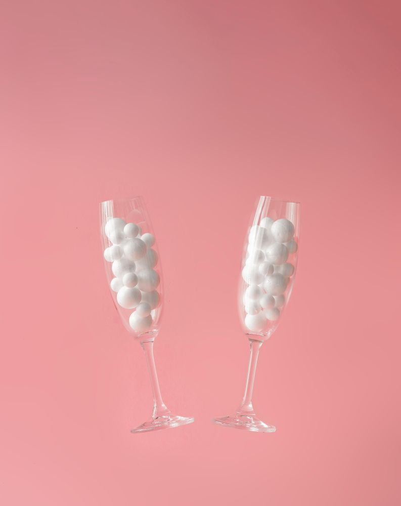 Pair of champagne glasses with light  bubbles with pastel background