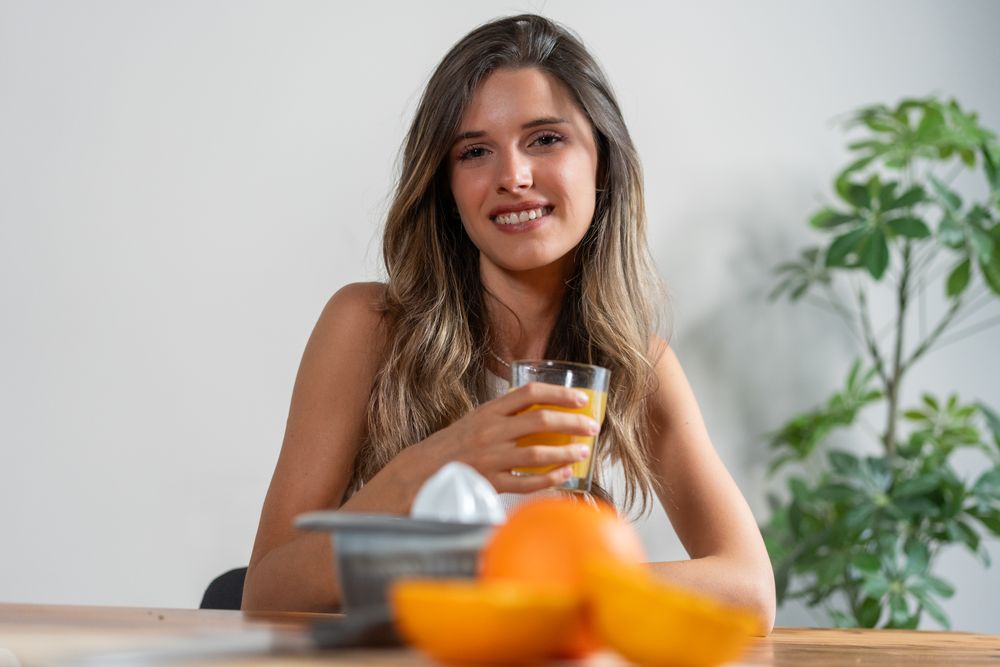 Woman drinking orange juice morning breakfast healthy lifestyle vitamin fresh fruit nutrition wellness smile