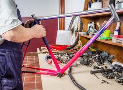 Hands of real bicycle mechanic cleaning frame bike