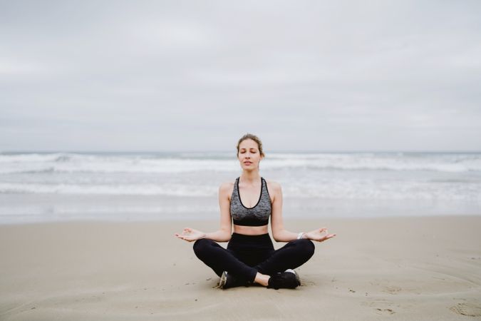 Woman meditating on the beach
