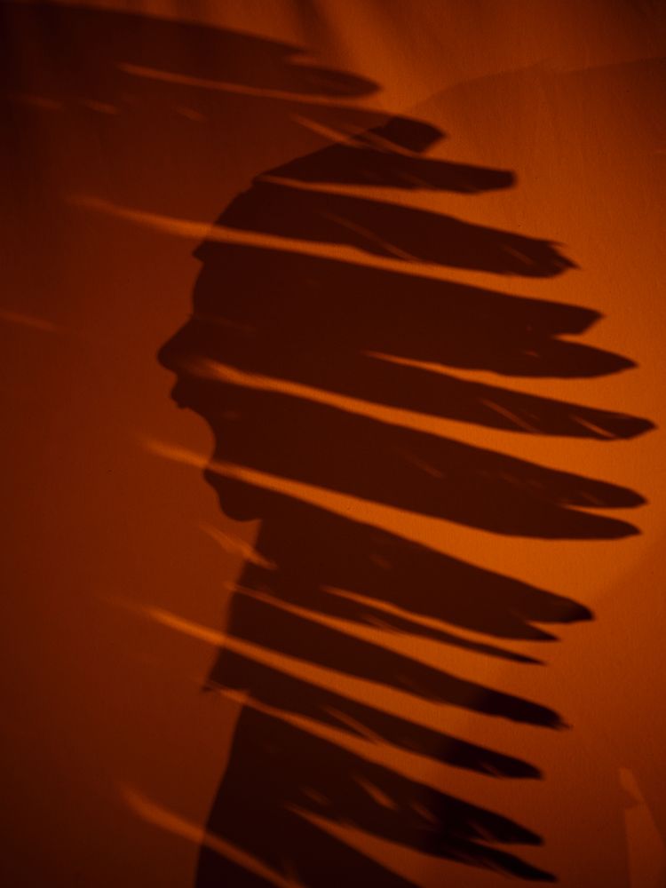 Shadow of anonymous screaming boy in Indian headwear