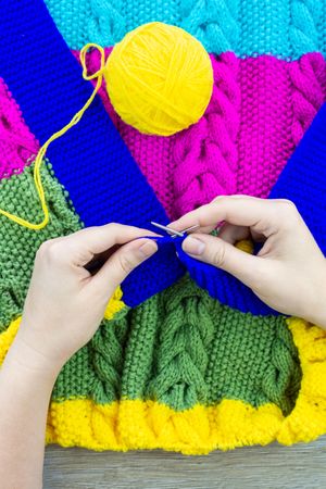 Woman knitting colorful shirt