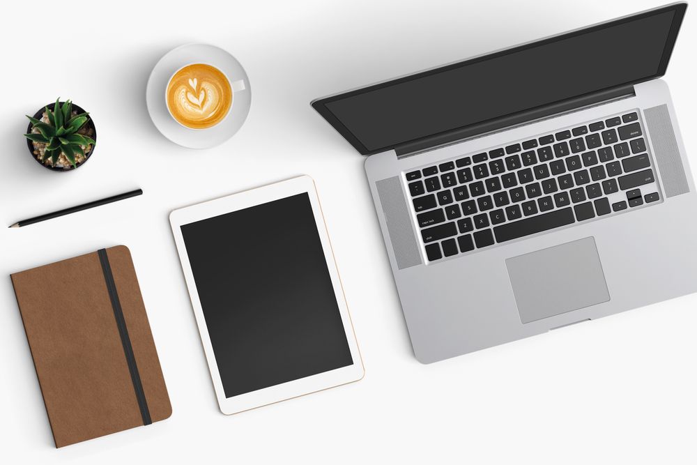 Modern workspace with coffee cup, smartphone, paper, notebook, tablet and laptop copy space