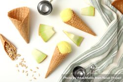Ice cream cones with pieces of fresh melon on a plain background 0JGQ2N