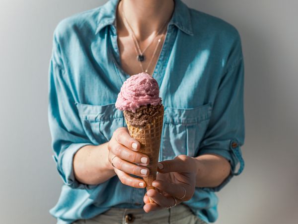 Ice cream scoop in cone in woman hands