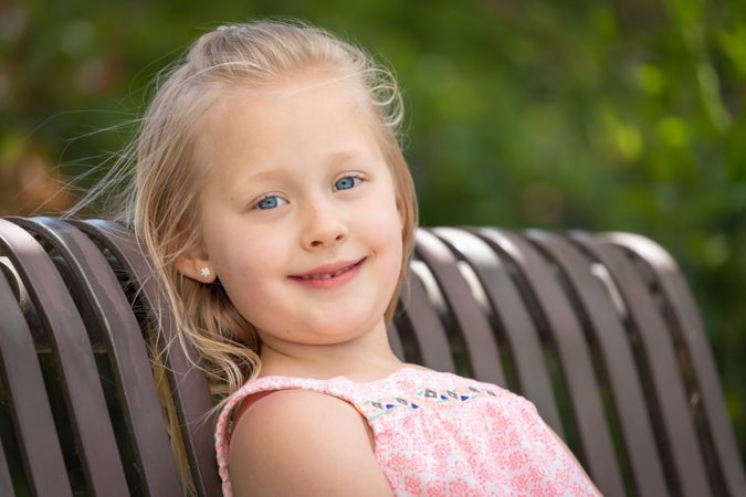 Young  Girl Portrait Sitting On The Bench At The Park