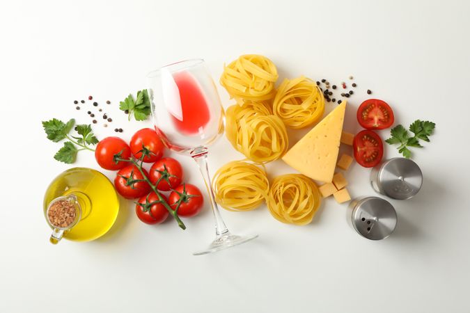 Composition with pasta and ingredients for cooking on plain background, top view