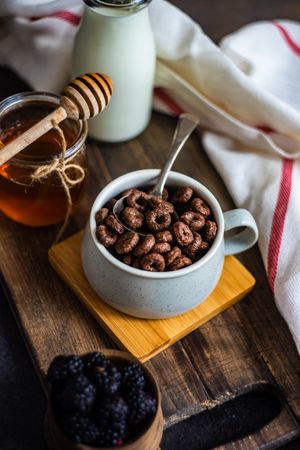 Delicious breakfast with chocolate cereal in mug with spoon