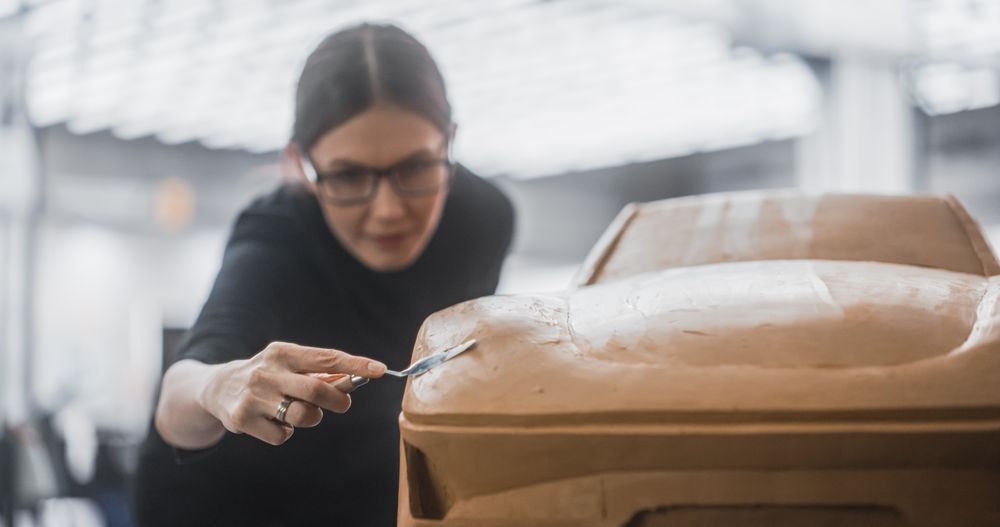 Female Designer Working on a Prototype, Sculpting Industrial Plasticine Clay 3D Model of a Sport Coupe