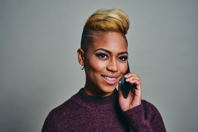 Smiling Black woman taking a call on a cell phone