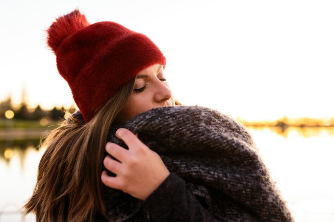 Charming woman in casual wear on shore of lake