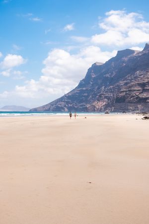 Back of two people walking on beach in Lazarote