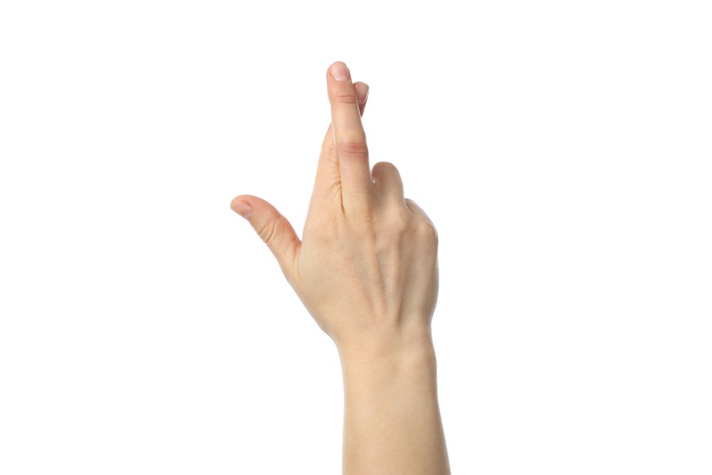Woman hand with crossed fingers isolated on plain background