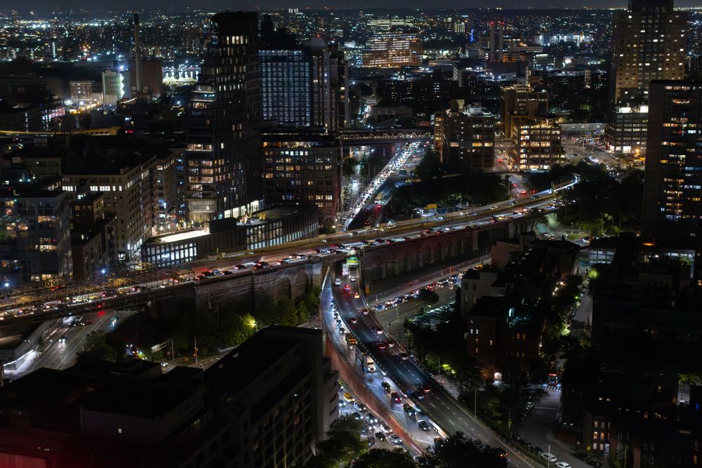 Aerial View of New York City. Helicopter Shot of a Busy Highway in New York City. Panoramic View with Traffic Around a Big City with Skyscrapers in the Background