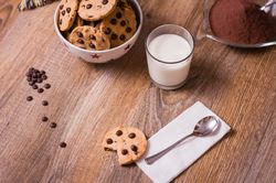 Chocolate chip cookies and milk on wood background