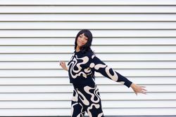 Woman dancing in front of lined wall