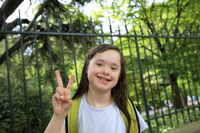 Cheerful child gesturing a peace sign with her fingers