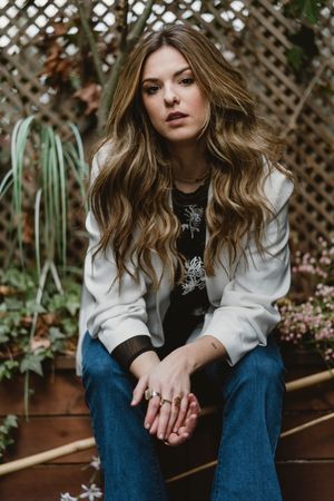 Woman sitting on planter in garden