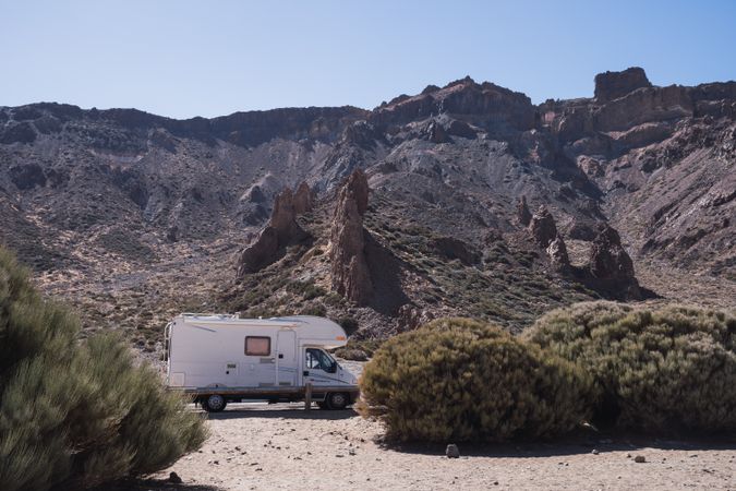 Camper on road against rocky mountains