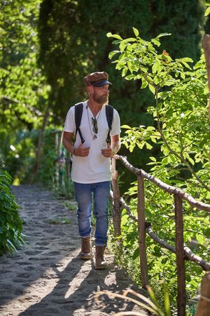 Mature man walking on fenced pathway in woods