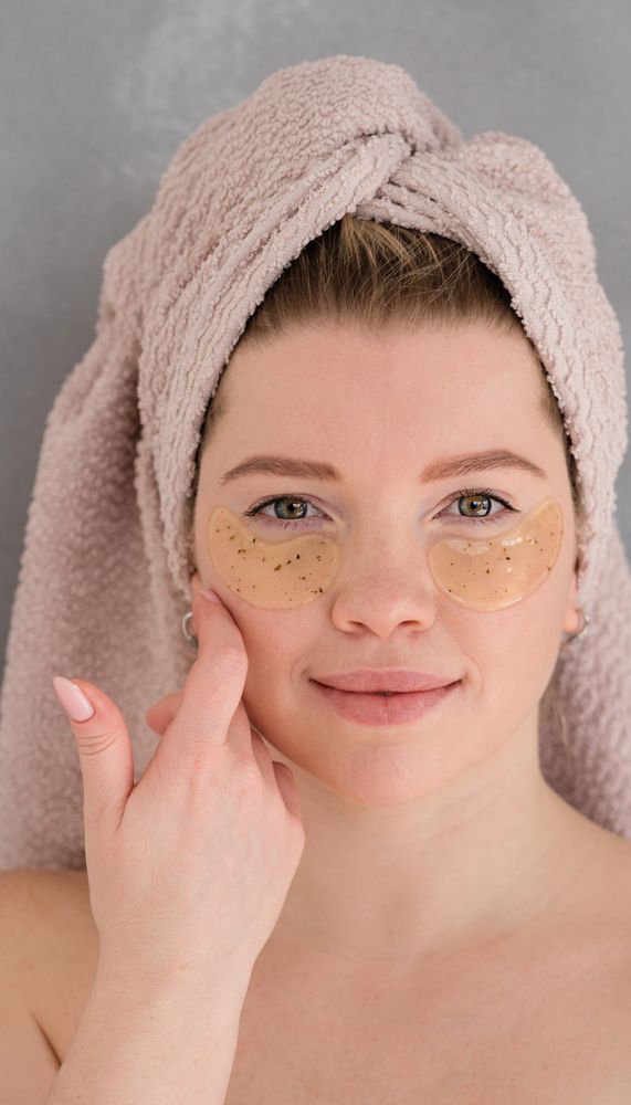 Applying eye patches in skincare routine.