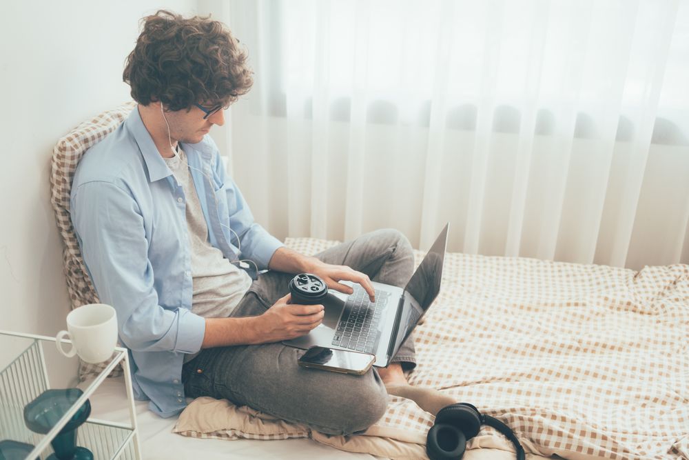 Man working from home drinking coffee and working on laptop