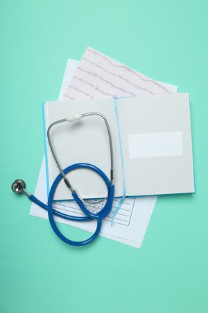 Papers, notepad and stethoscope on green background, top view