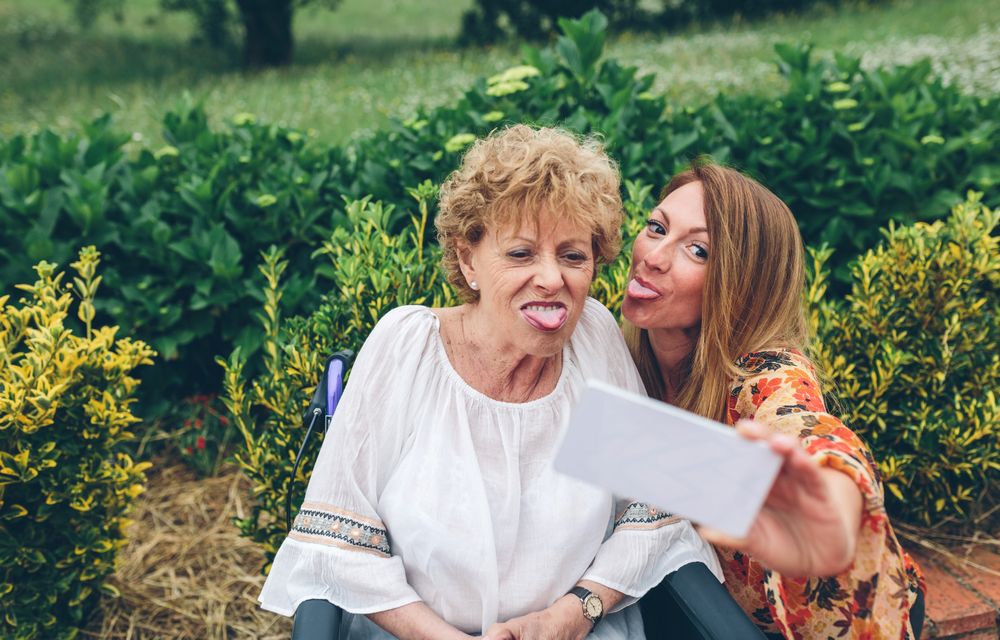 Woman taking selfie with her mother in wheelchair
