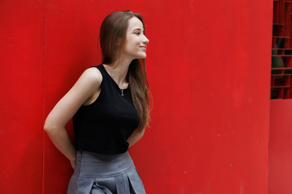Woman standing with red background
