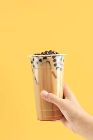 Female Hand Hold Taiwan Boba Pearl Milk Tea with Liquid palm Sugar Syrup