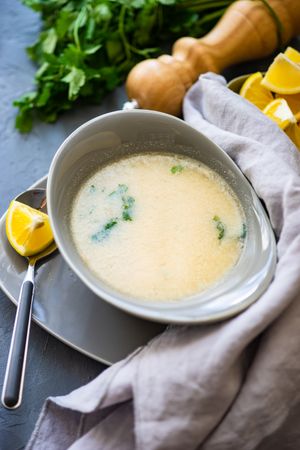 Top view French onion cream soup served with lemon and parsley