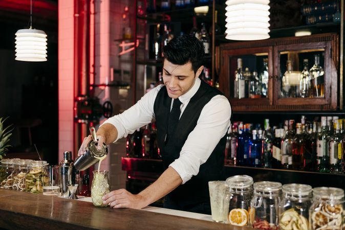 Barman working mixing pouring drink in a glass