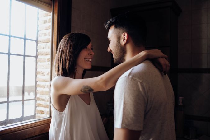 Happy couple embracing in kitchen