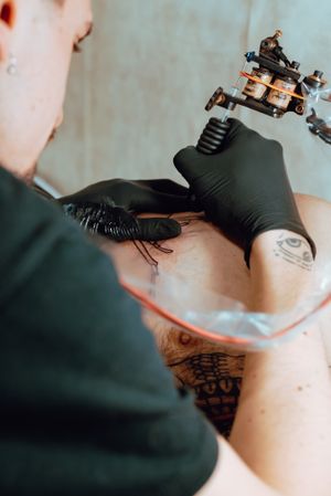 Tattoo artist working on client