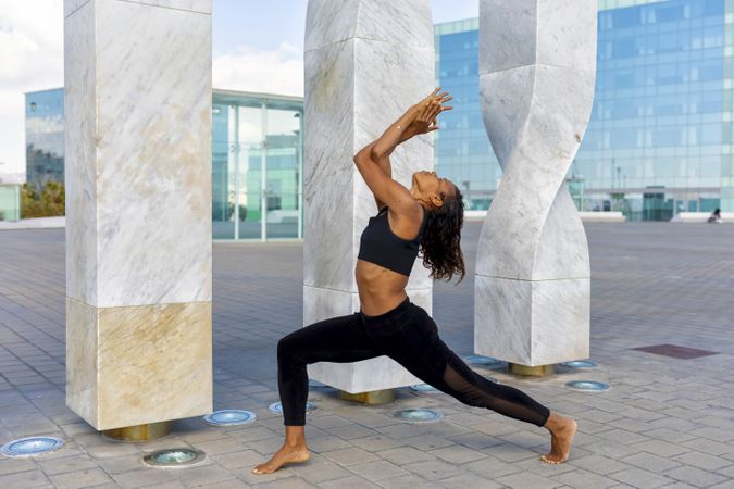 Woman doing yoga in front of sculpture 