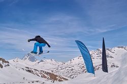 Unrecognizable snowboarder jumping on slope