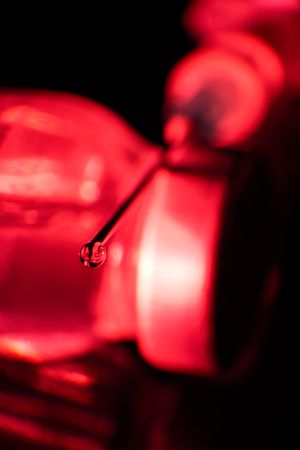 Hypodermic syringe needle with droplet of liquid on tip